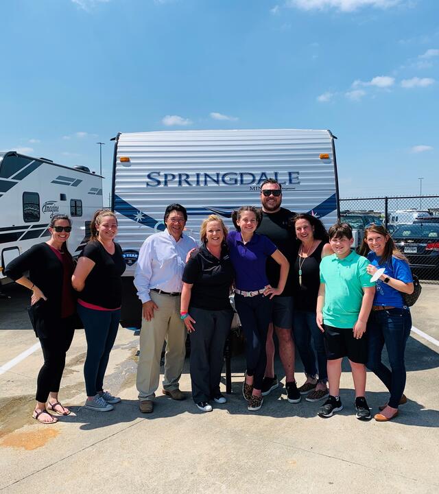Carson with travel trailer and family