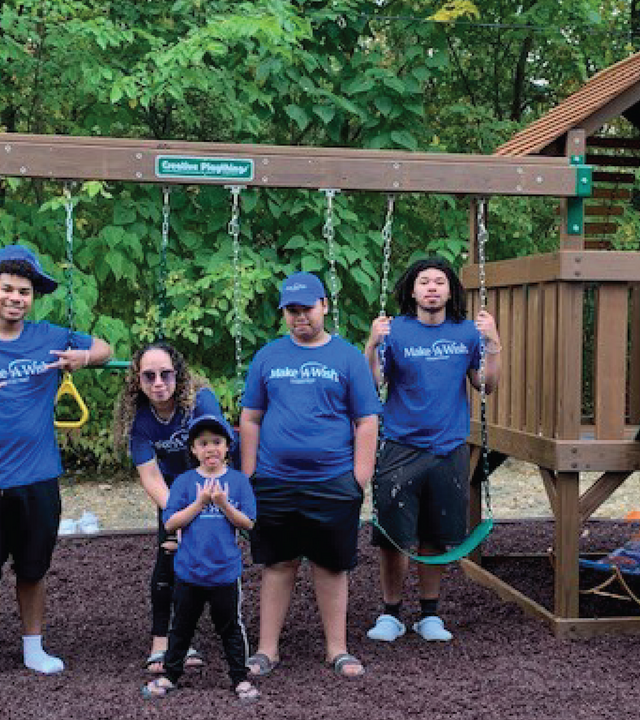 Jariel with family in front of new swing set