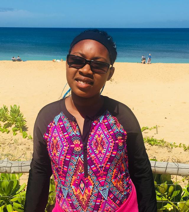 Wish Kid Malayna smiling by the beach in Hawaii.
