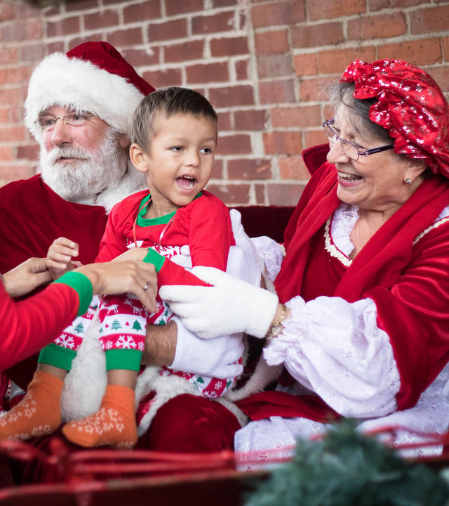 Santa and Mrs. Claus hold four-year-old Michael in their sleigh