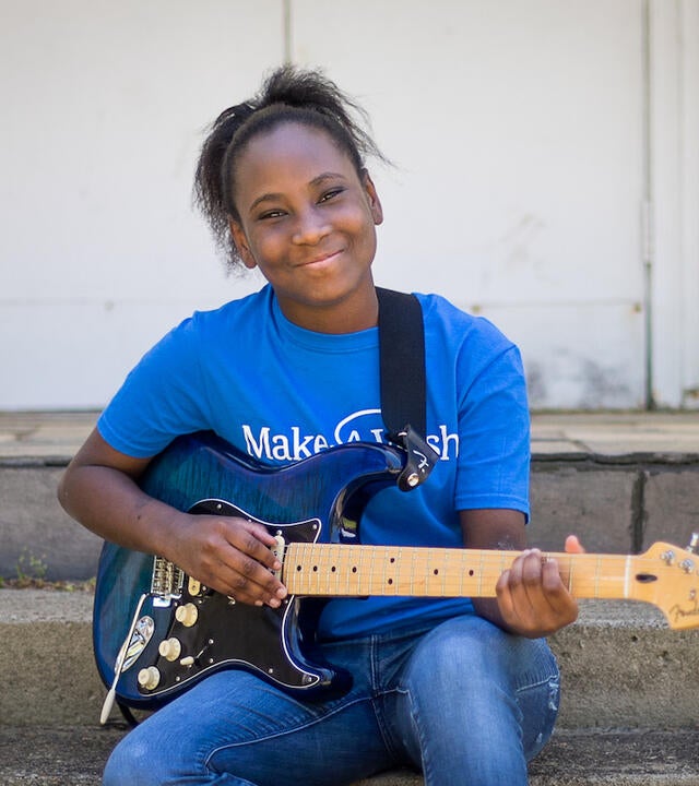 Wish kid Deonna with her blue electric guitar