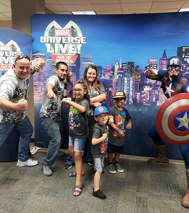 Volunteer Matt with wish kid posing with Captain America