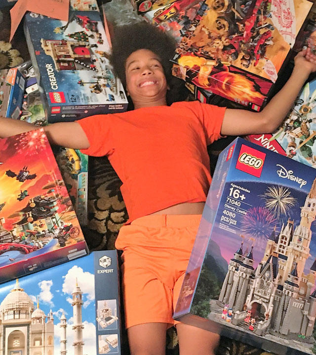Noah with all of the LEGO sets from his wish
