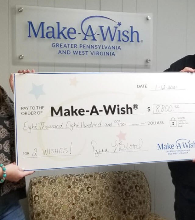Volunteers Diana and Doug Blood generously present their donation from their Cans for Wishes fundraising event.