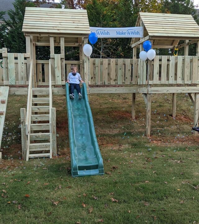 Gavin's wish to have an adaptive playset, Gavin on the slide