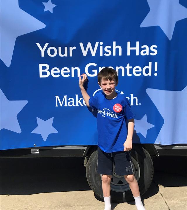 Britton stands in front of his camper on his wish reveal day.