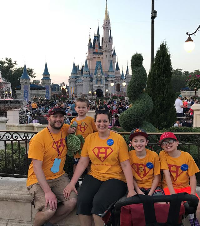 Henry and his family pose in front of Cinderella's Castle at Magic Kingdom.