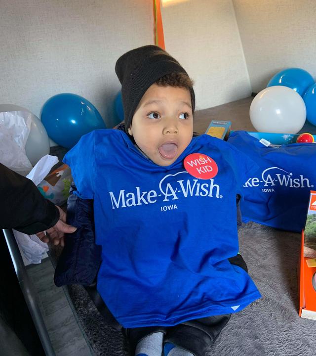 Khami, in his Make-A-Wish shirt, sits in his camper for the first time.