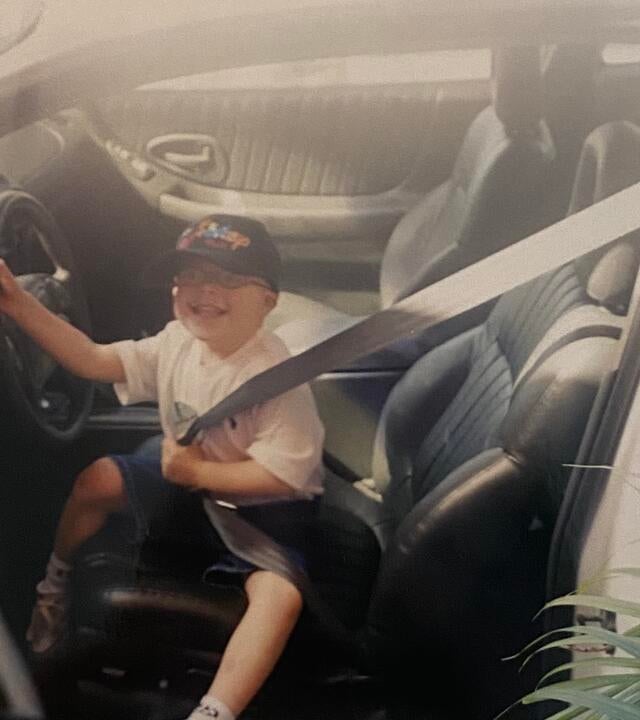 Lucas sits in a car.