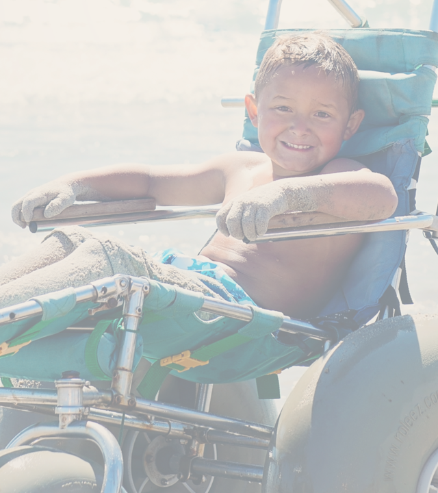 Wish kid on accessible sand bike