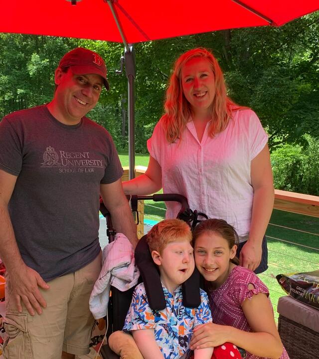 Nolan, his sister, and his parents, pose for a photo on their new deck