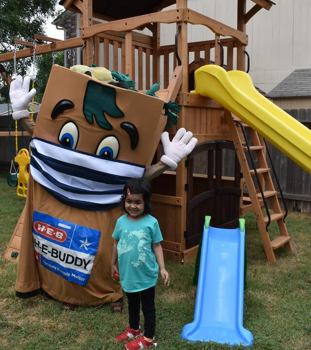 Wish Kid Sophia and HEBuddy standing in front of Sophia's new playset