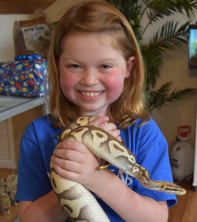 wish kid Mazie smiling and holding a snake