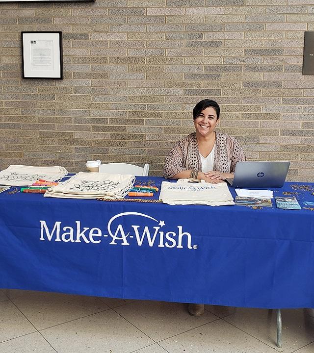 Angela working Make-A-Wish table at event