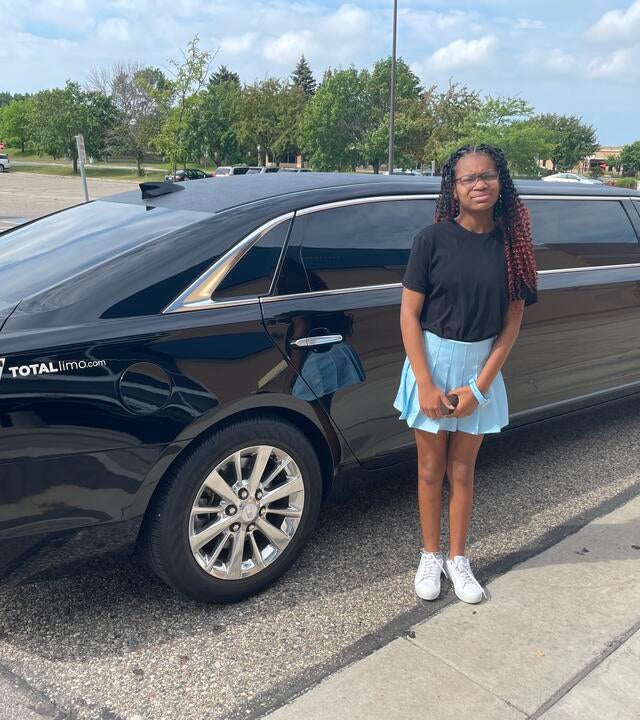 Carrington in front of a limo on her wish day. 