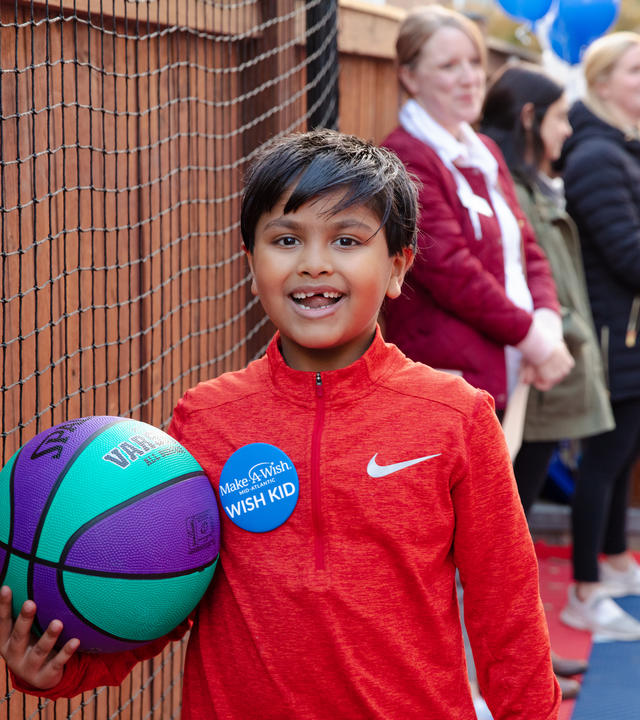 Zain smiles with a basketball