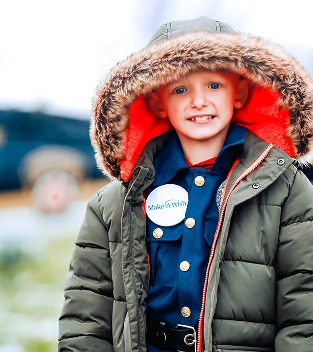 Landen stands outside in front of the helicopter.