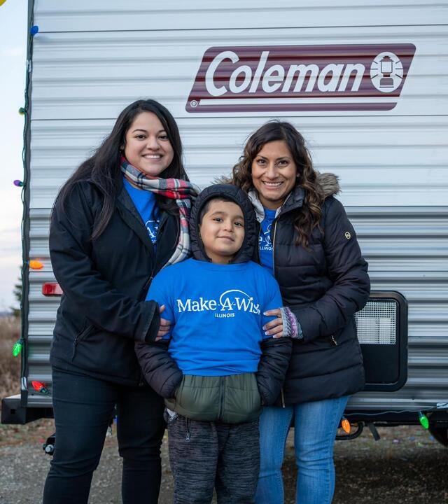 Wish child Sebastian smiling with Make-A-Wish volunteers