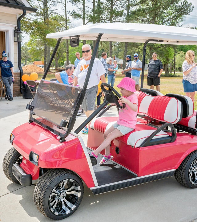 Izzy sitting in her brand new pink golf cart