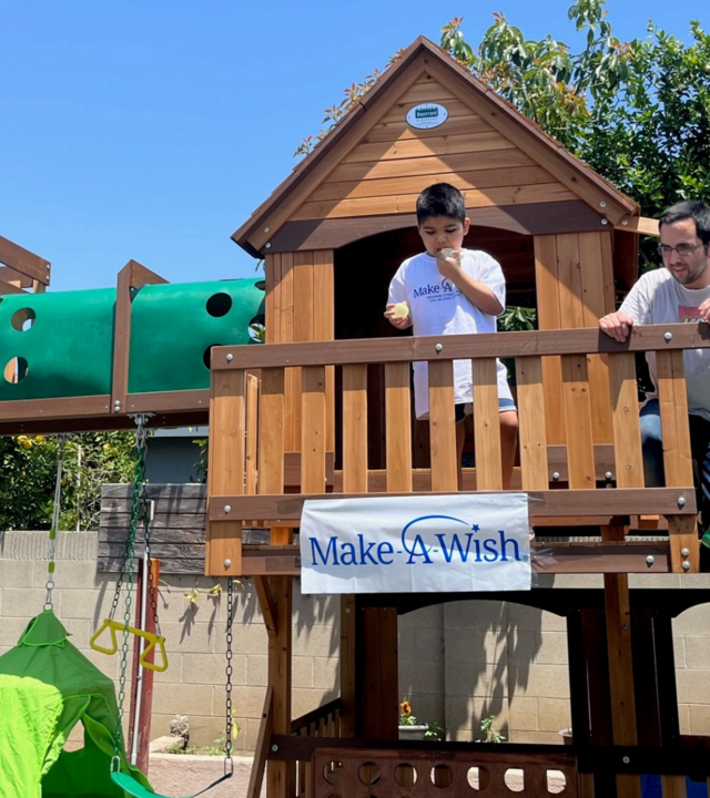 Ej stands on his play structure with water balloons