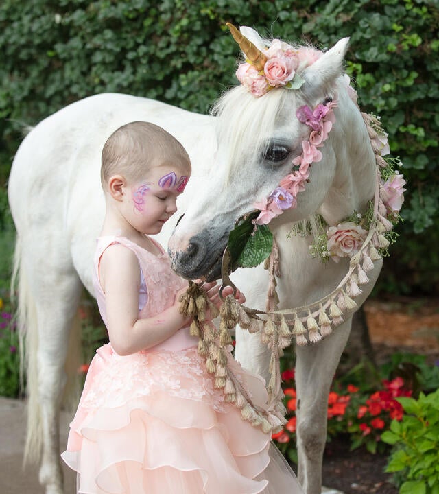Emery in her ballgown with unicorn.
