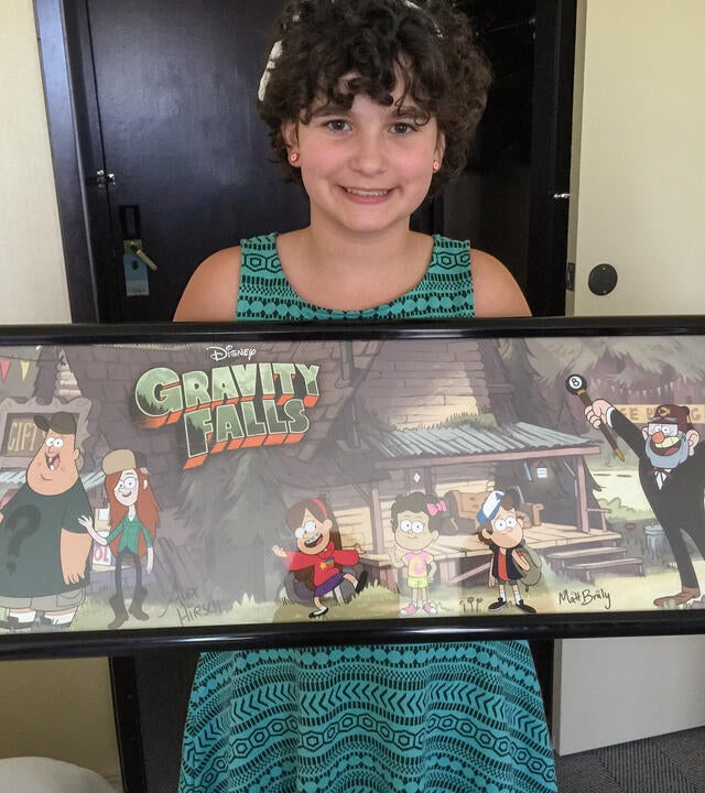 Georgia holding framed Gravity Falls poster