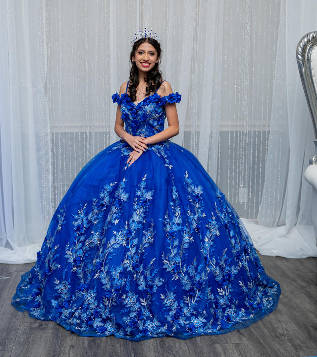 Wish kid Alexis standing in her blue quinceañera dress smiling