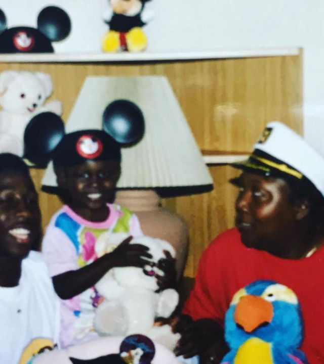 Three people sitting together, a child and an adult are hugging