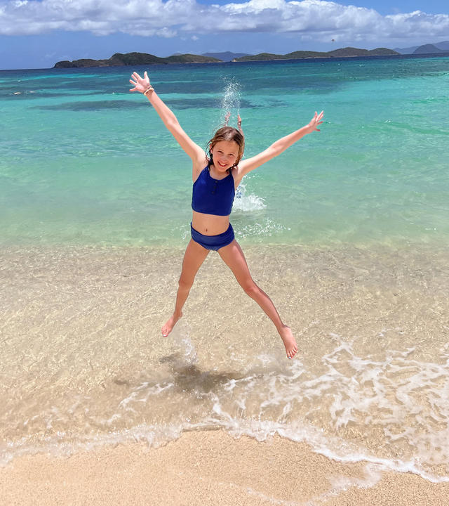 wish kid Claire jumping in the air on the beach
