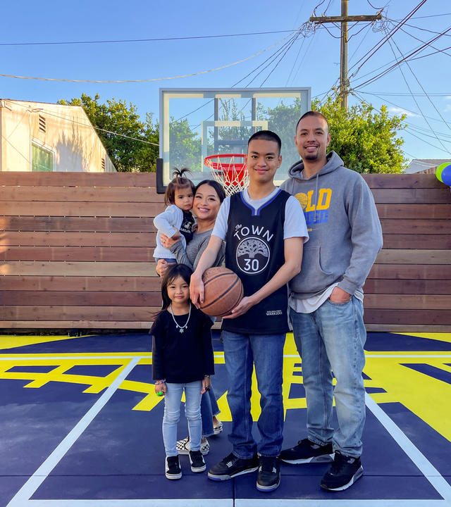 Wish Kid Isaiah with his family on his new backyard basketball court