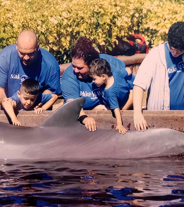 JonPaul and family petting a dolphin