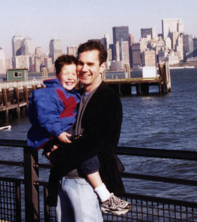 Matthew being held by his uncle Lucas with the New York city skyline in the background