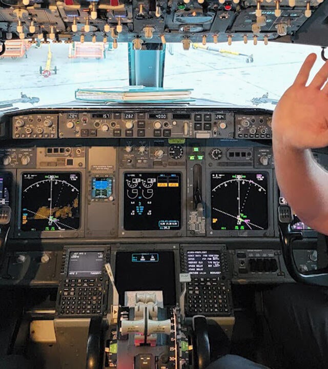 Alexandra in cockpit of airplane with Alaska Airlines pilot