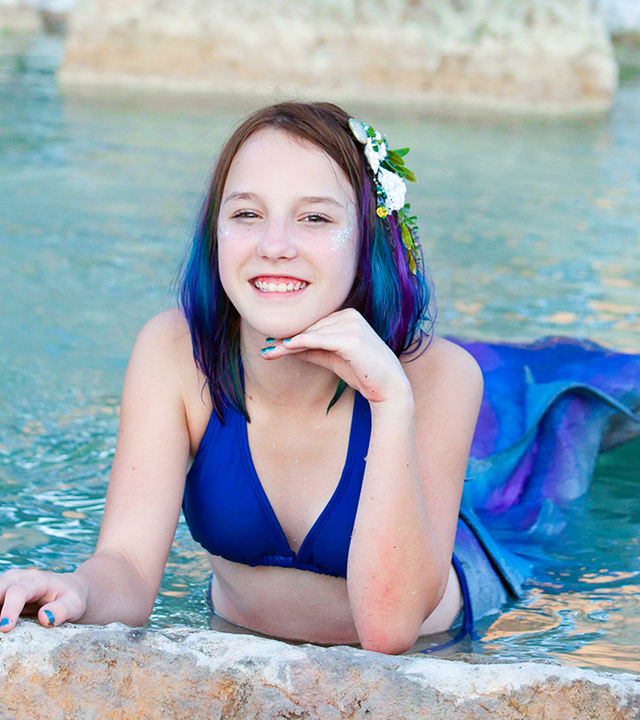 Emily poses in the water with her custom mermaid tail.