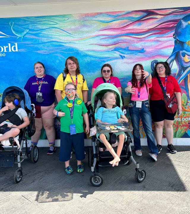 Wish kid Poseidon and his family each wearing a different color representing a rainbow