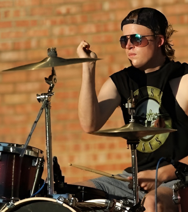 wish kid jack playing the drums outside 