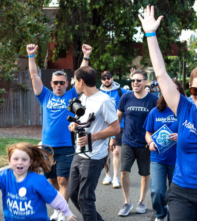 Walkers celebrate crossing the finish line at 2024 Walk for Wishes