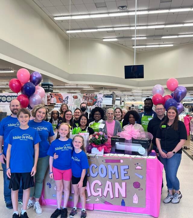 wish kid and her family smiling with craft store employees