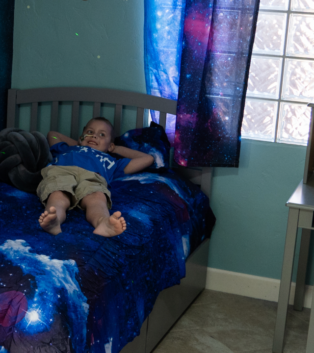 Aleksander enjoys laying in his new bed on his wish day!