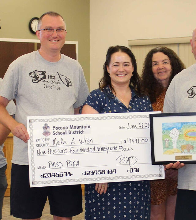 Make-A-Wish Regional Manager Maggie O'Brien in the center, with a donation presented by Pocono Mountain West High School faculty members on behalf of the whole school district.