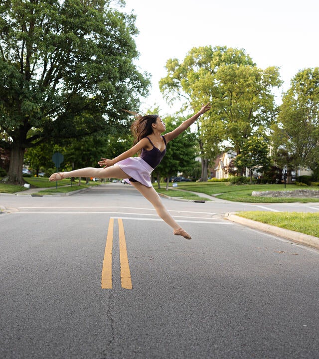 Wish kid Moci practicing ballet leap in front of home