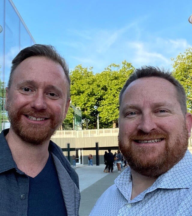Caleb and Derek standing outside with the Space Needle in the background