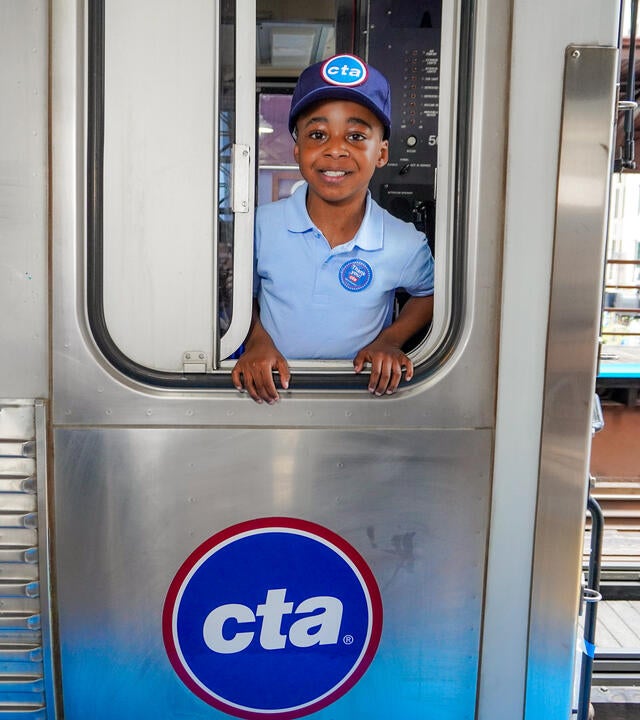 Wish kid Idris standing in window of CTA train looking at the camera