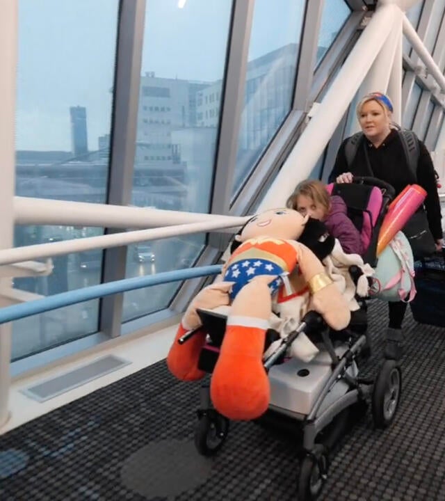 Mom and wish child entering hospital across pedestrian bridge