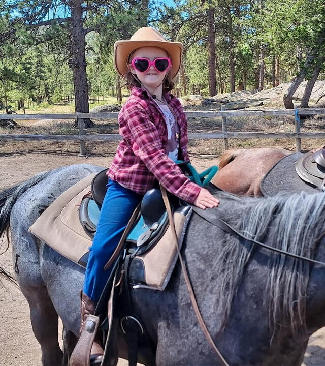 Wish kid Mary Alice riding a horse wearing a cowboy hat and sunglasses
