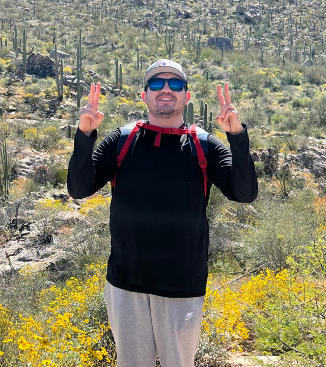 Jose Cazares, April volunteer of the month, standing in Arizona desert