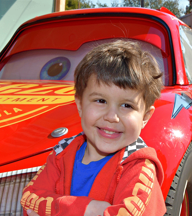 Louis standing in front of Lightning McQueen