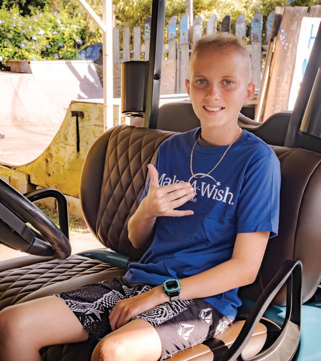 Kainoa sitting in his new customized golf cart