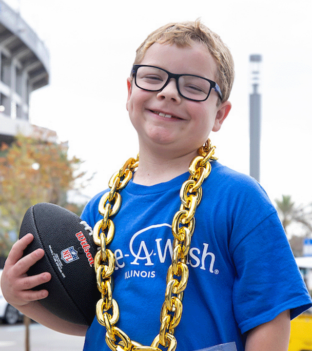 Blaze holding a football in front of Jaguar's stadium