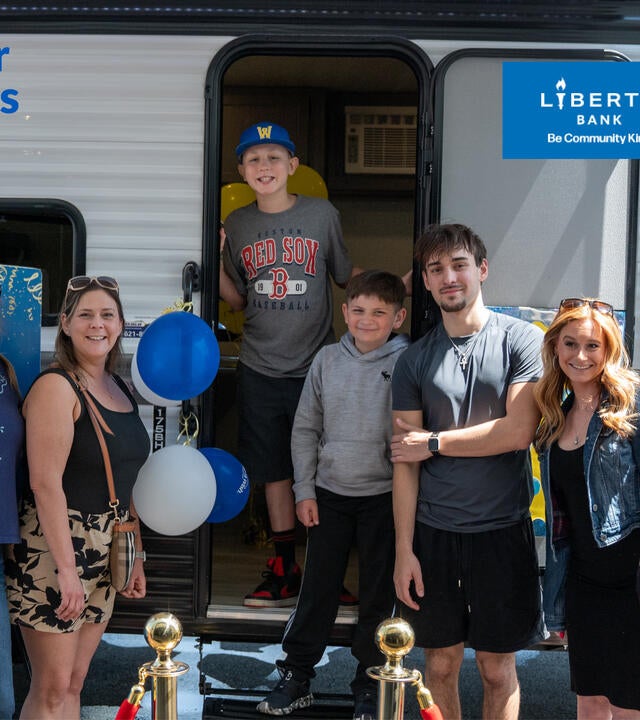 Chayse standing in the doorway of a camper with his family standing in front